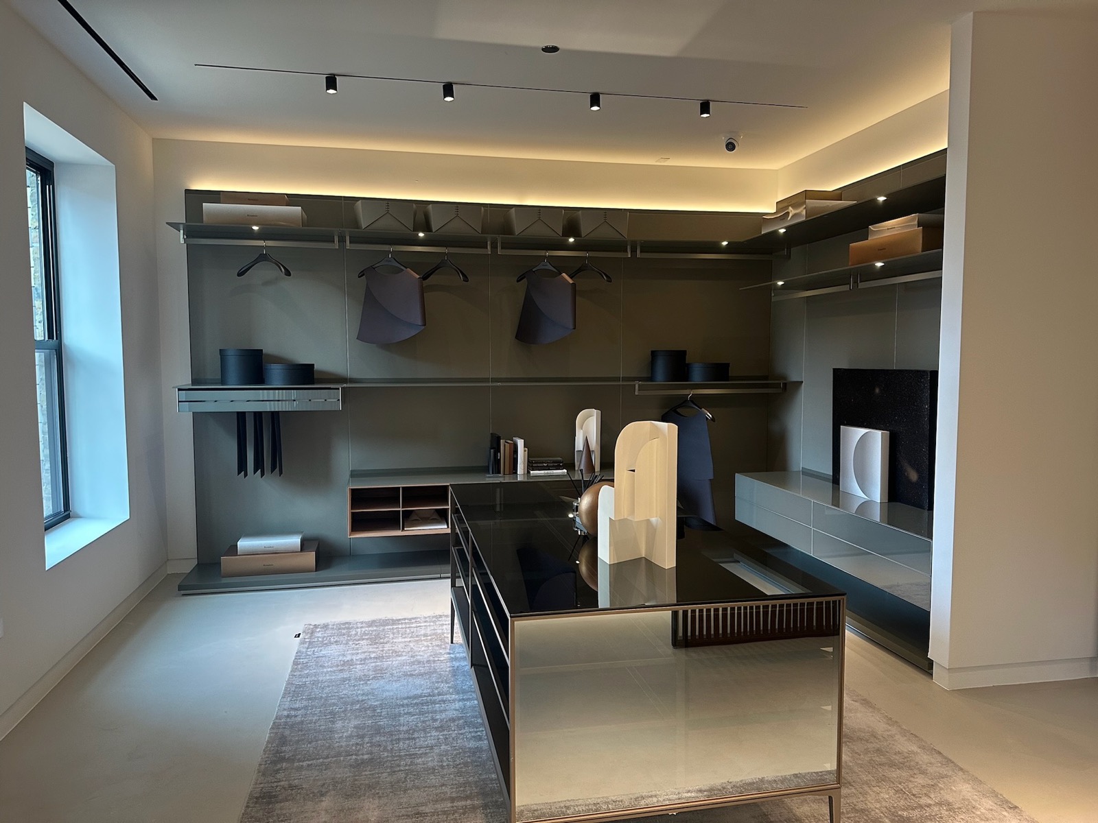 An open wardrobe system around a glass-topped island
